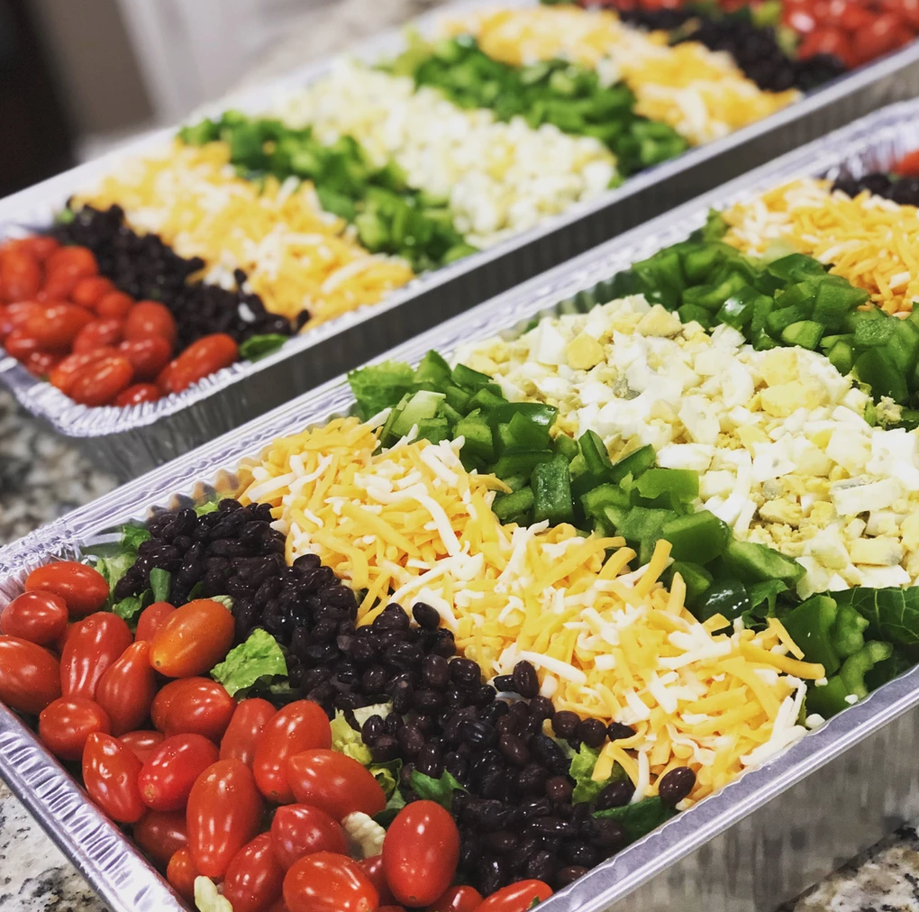 Tomatoes, black beans, cheese, peppers displayed in a dish from The Catering Cafe